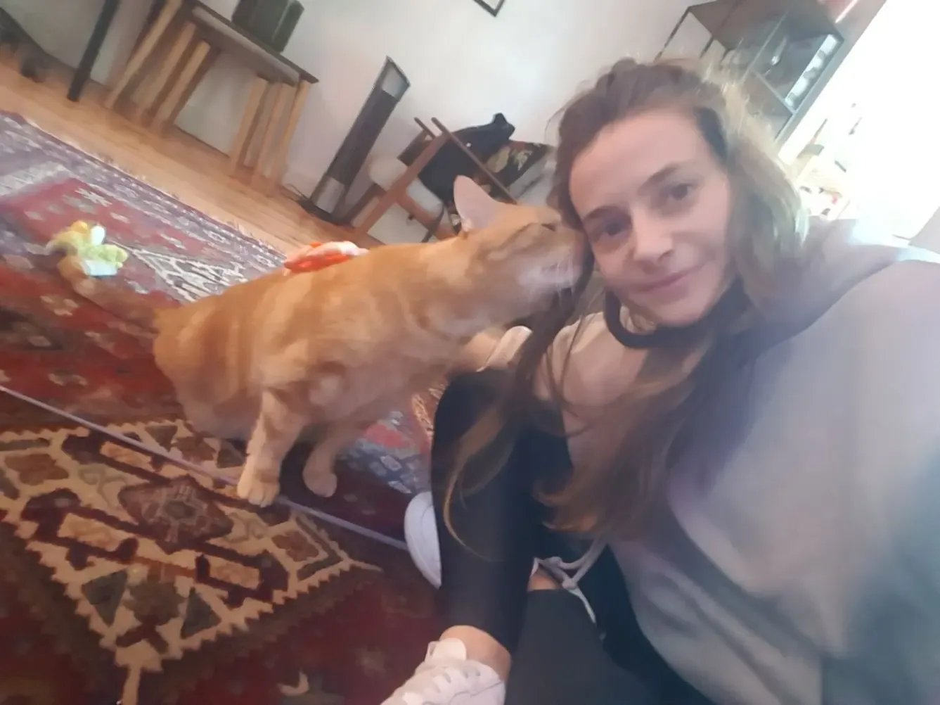 Fanny et un chat roux qui se frotte contre sa joue